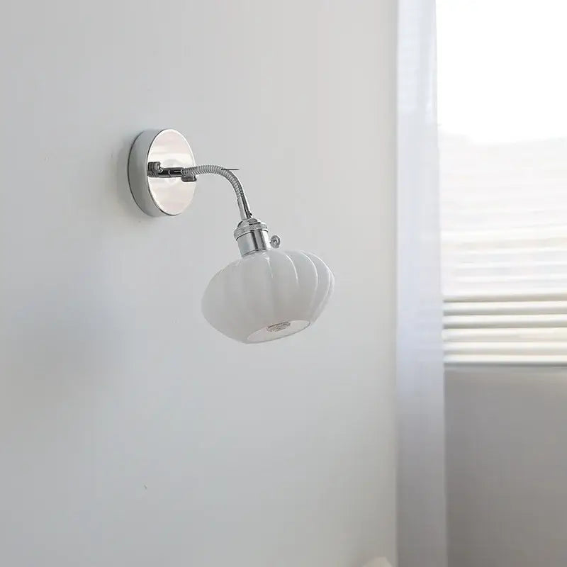 Chrome adjustable arm wall lamp with ribbed glass shade – bedroom