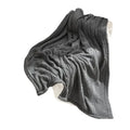 Dark gray fishbone knit blanket with white fleece lining living room