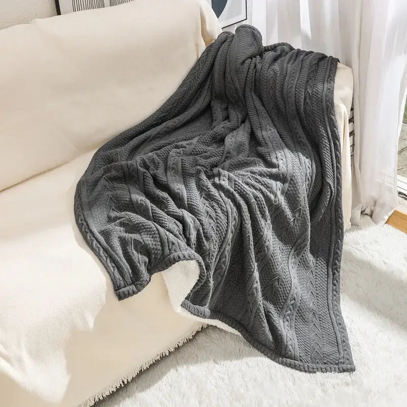 Dark gray fishbone knit blanket with white fleece lining living room