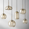 Modern smoked glass pendant lights with brass accents for kitchen island