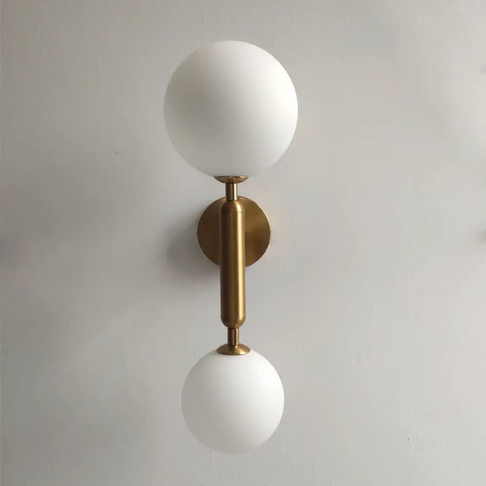 Modern golden led wall sconce with milky glass globes for bedroom