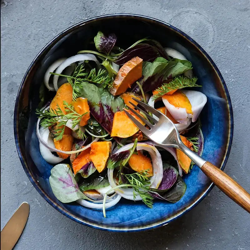Rustic deep blue ceramic salad bowl with wooden fork dining room